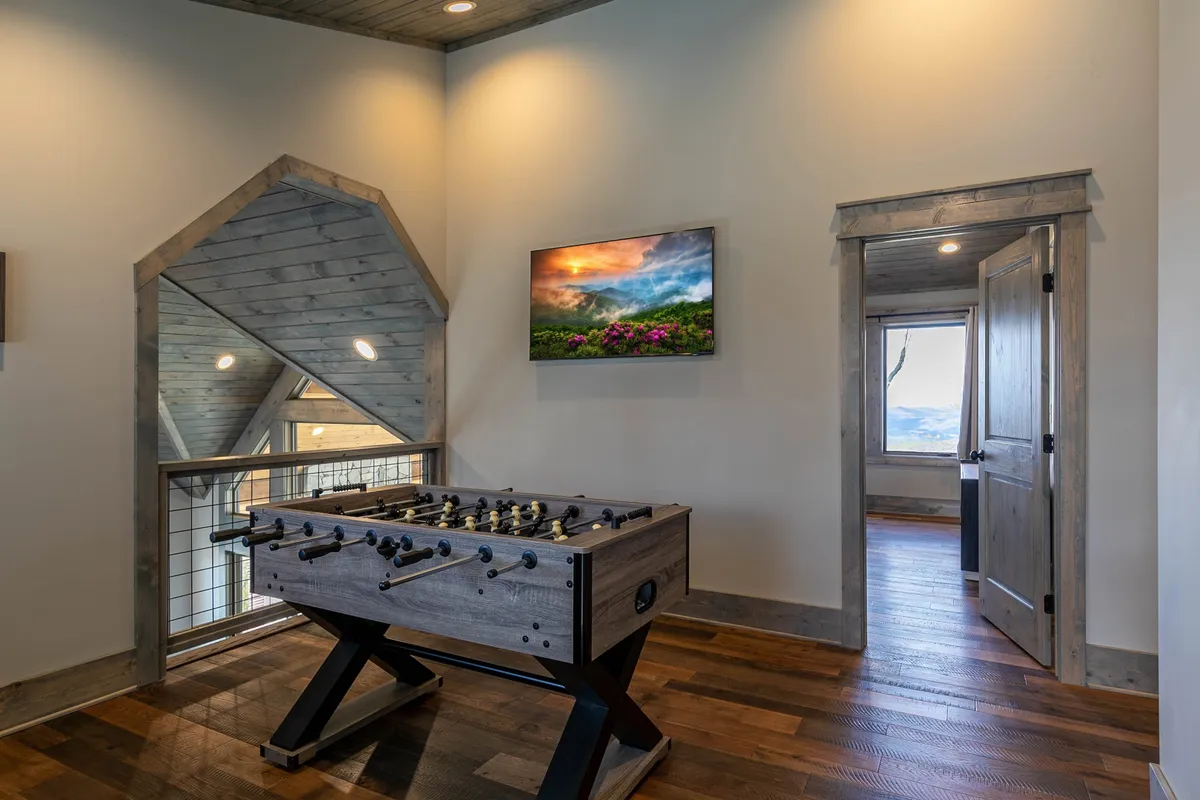 A close-up of a foosball table set against a backdrop of landscape artwork and a mirror, this image highlights the playful and interactive aspect of the game area. The setup encourages guests to enjoy friendly matches and social interaction.